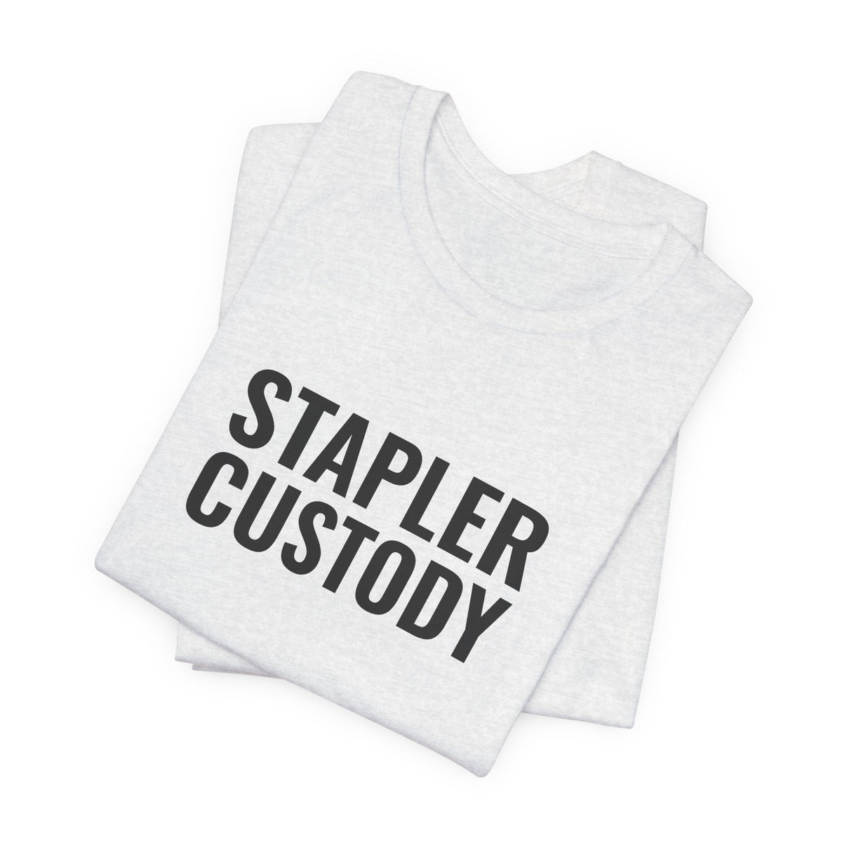 Folded ash tee showing the “Stapler Custody” print