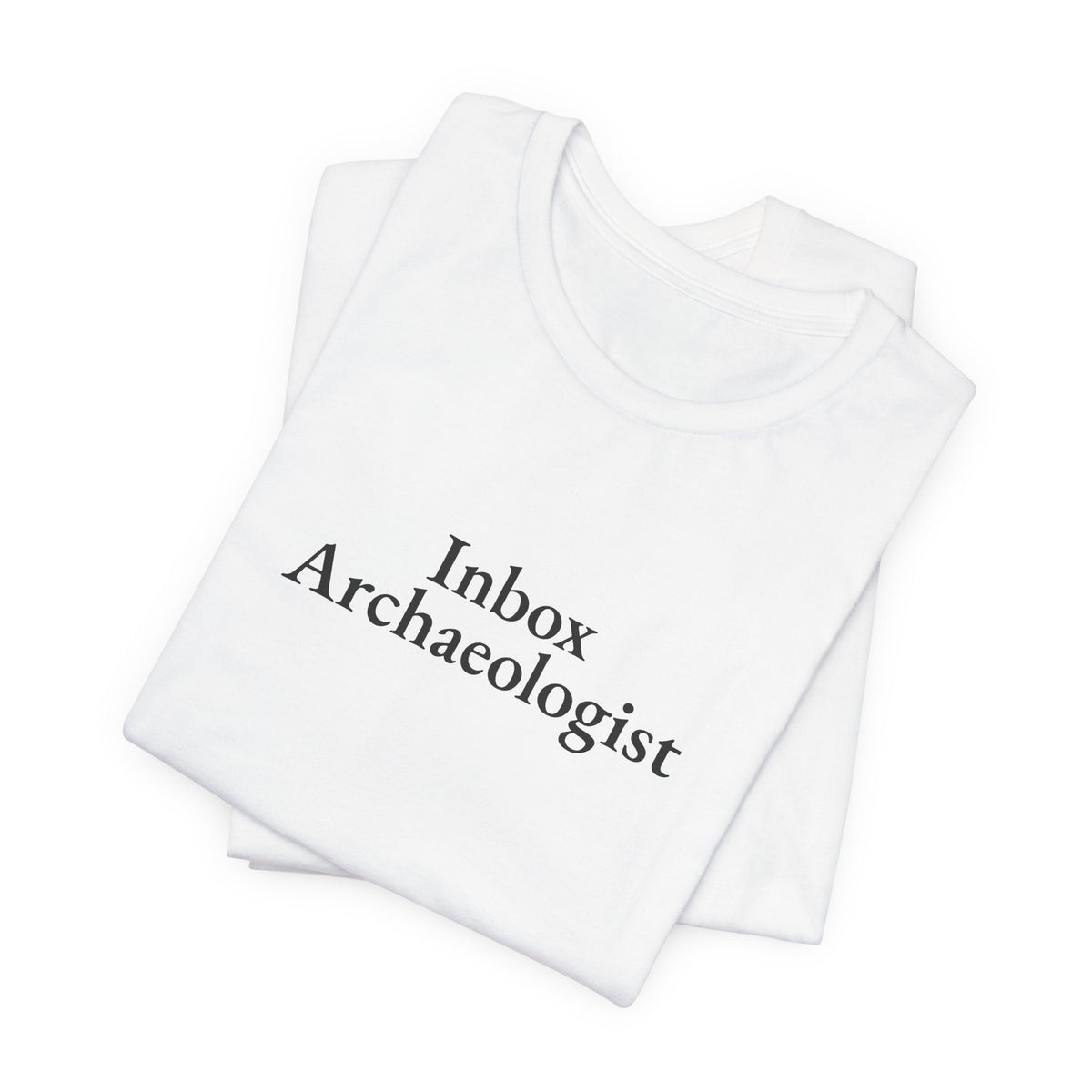 Folded white tee showing the “Inbox Archaeologist” print