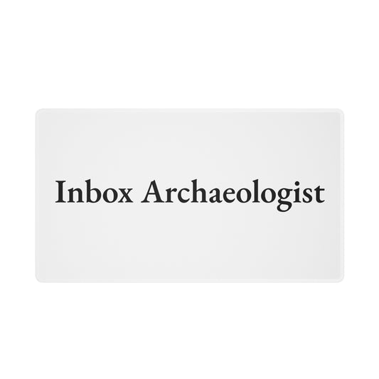 White “Inbox Archaeologist” desk mat, shown from the front