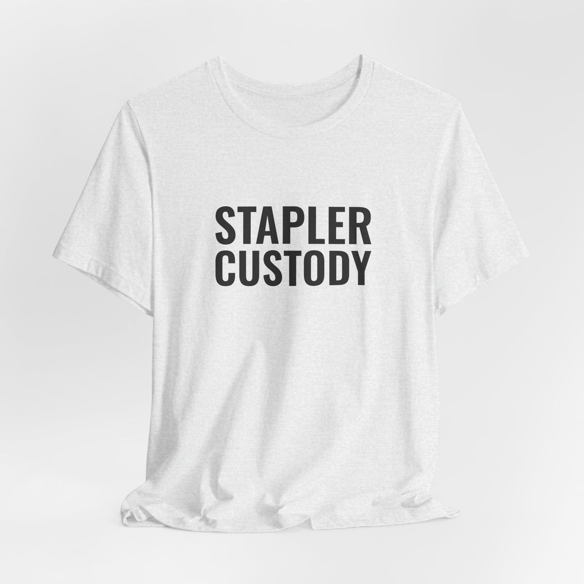 The ash “Stapler Custody” tee hanging on a hanger