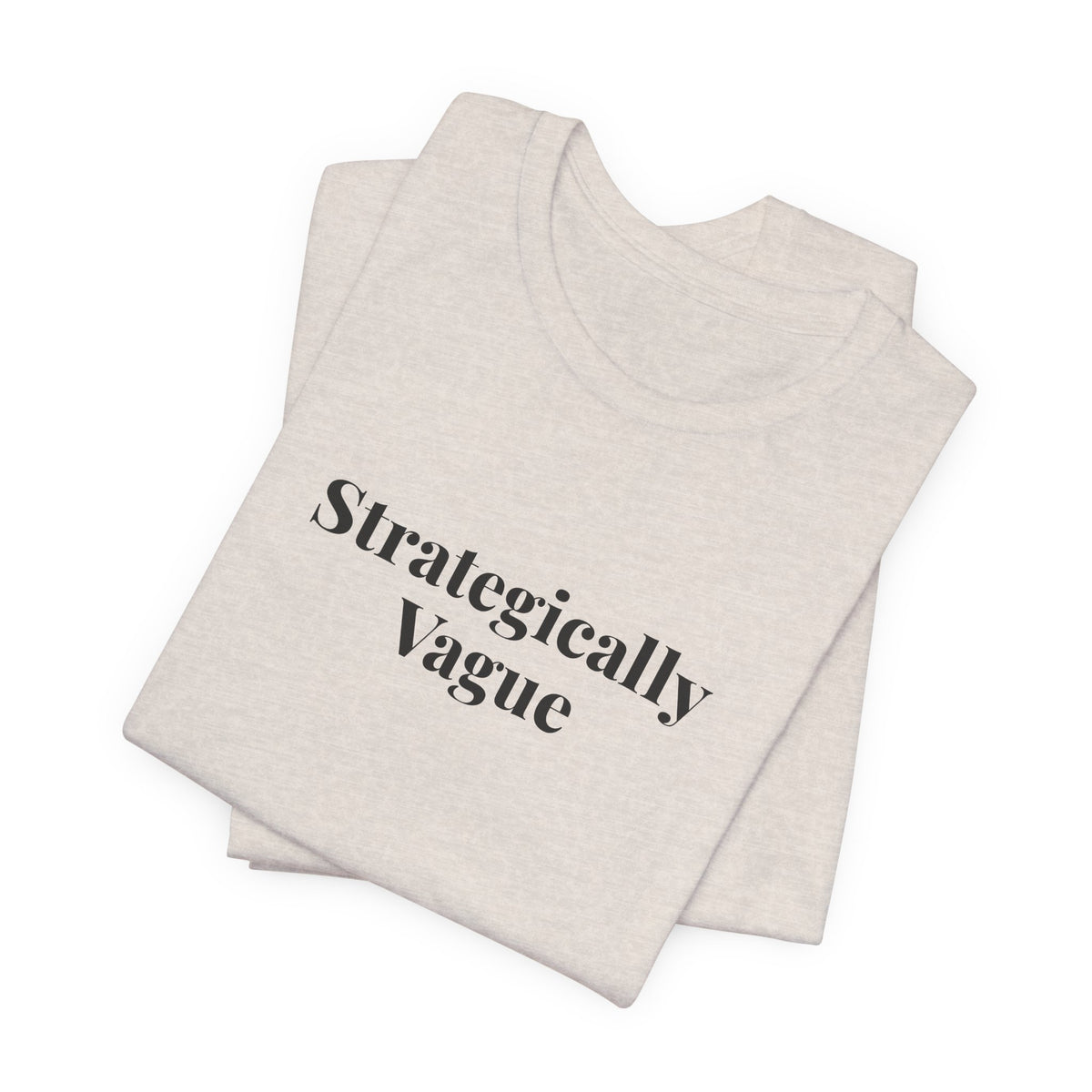 Folded heather dust tee showing the “Strategically Vague” print