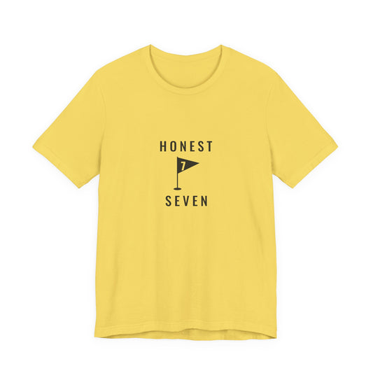 Yellow “Honest Seven” golf tee, front view with the centre-chest print