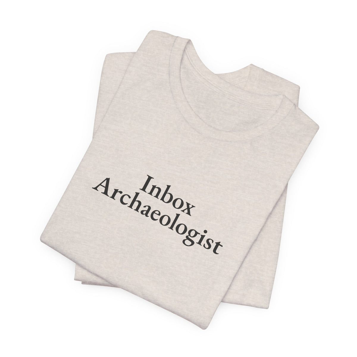Folded heather dust tee showing the “Inbox Archaeologist” print