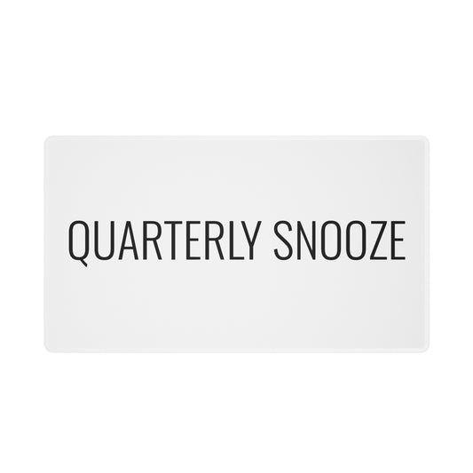 White “Quarterly Snooze” desk mat, shown from the front